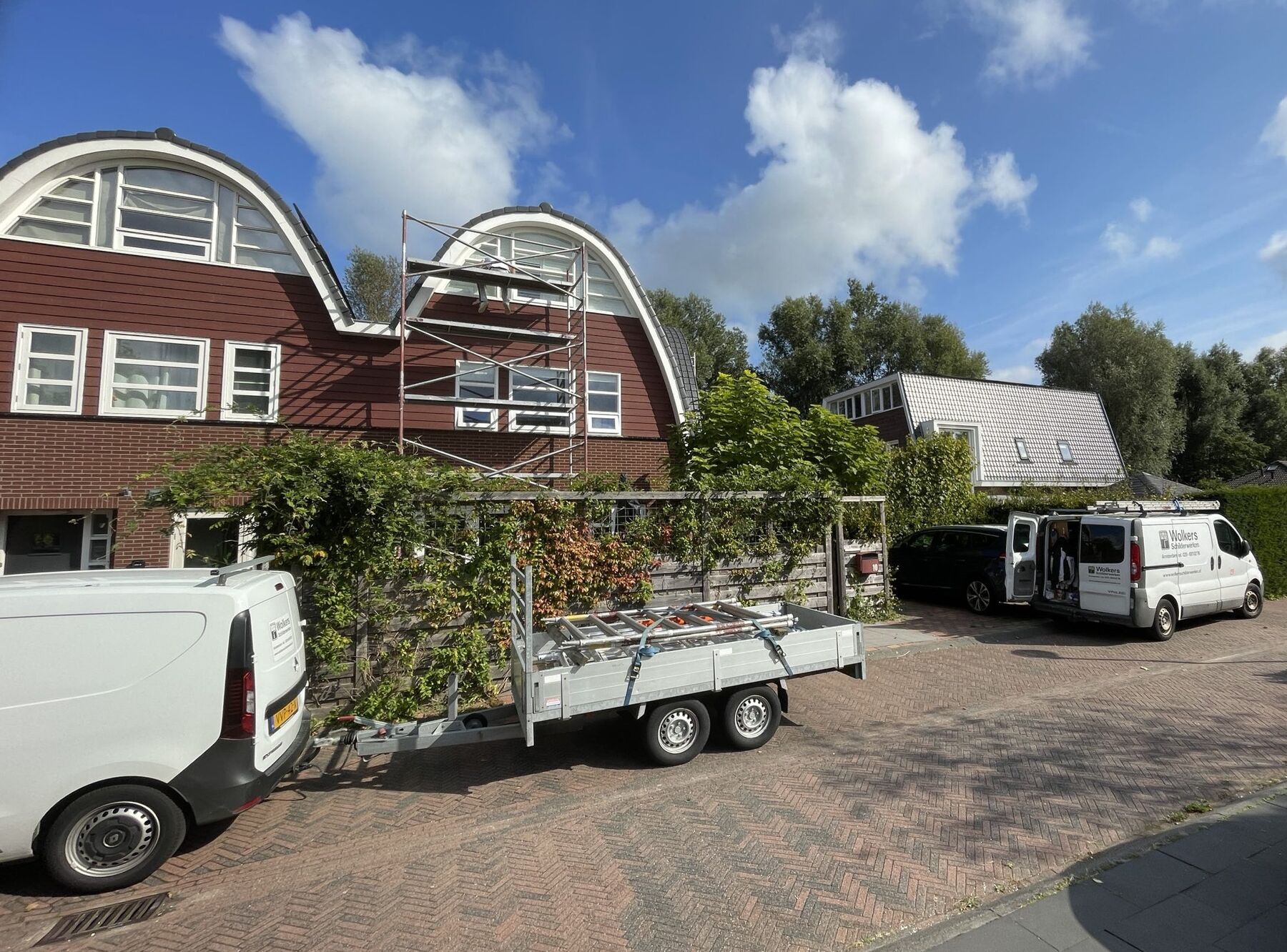 Bussen en aanhanger van Wolkers bij een project