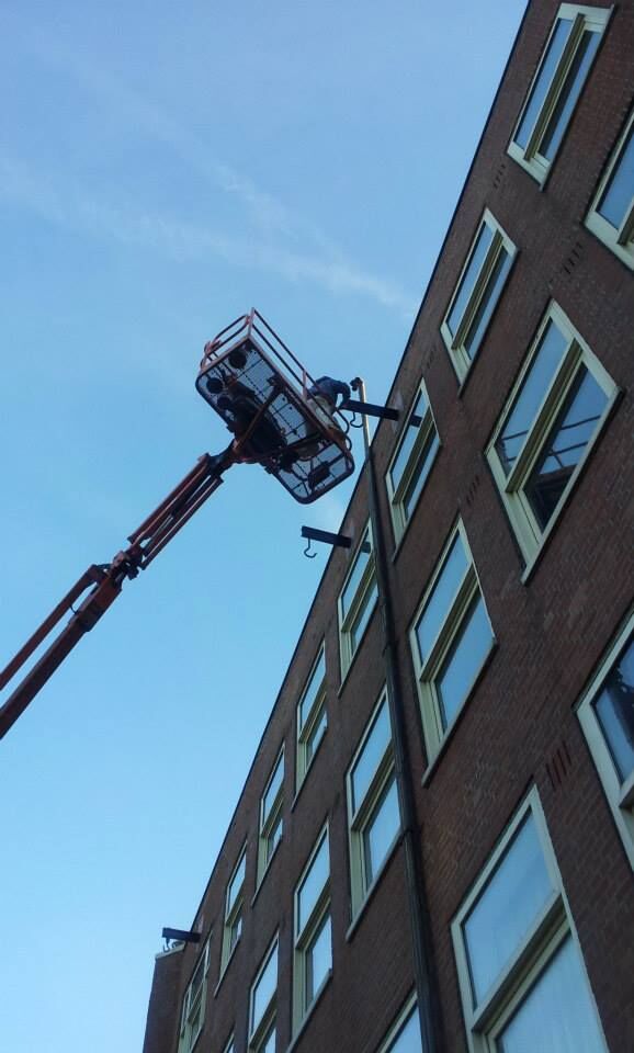 Hoogwerker langs een bakstenen gevel