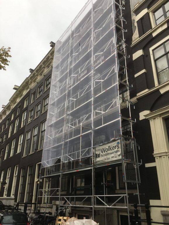 Steiger met doek voor een smal grachtenpand