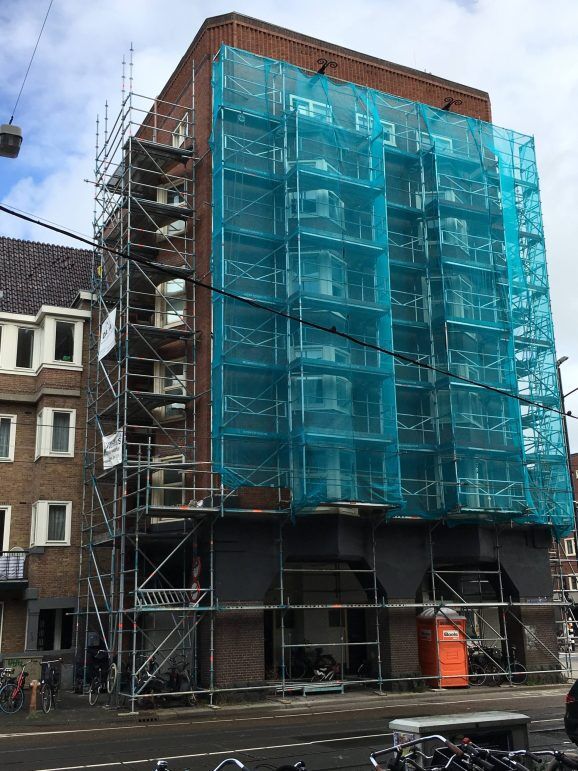 Volledig ingepakte steiger rond een appartementencomplex