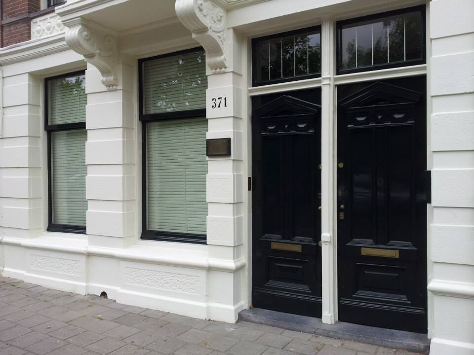 Gerestaureerde monumentale voordeur met wit stucwerk en zwart gelakte deuren